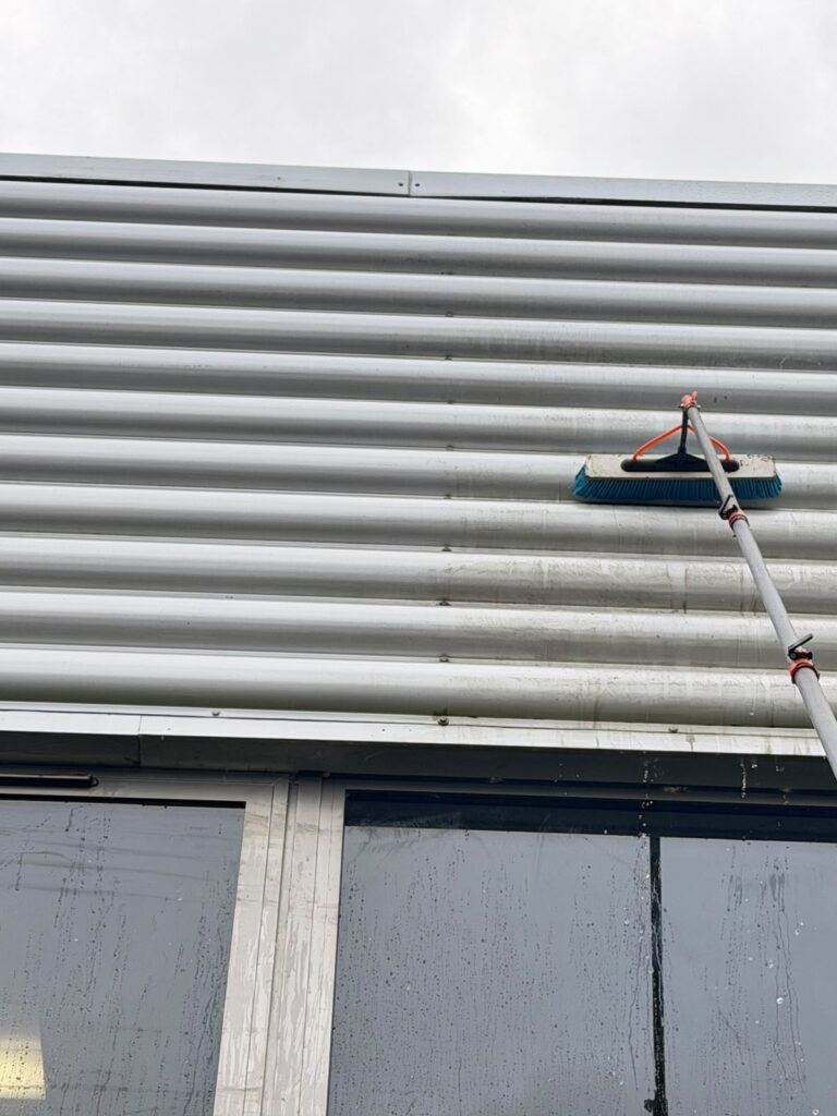 Water-fed pole cleaning of commercial building cladding