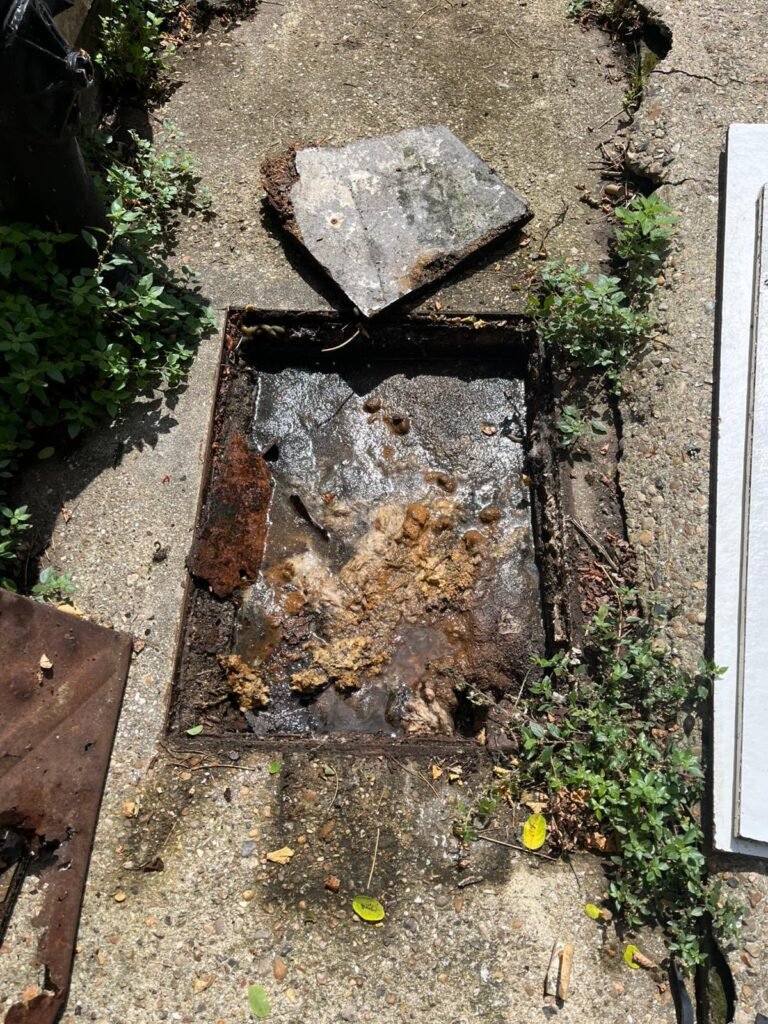 Broken, rusted inspection chamber cover before repair