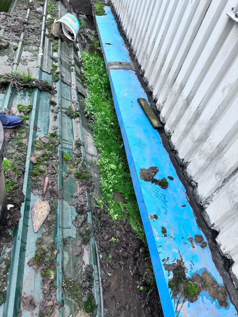 Debris being cleared from a commercial roof gutter